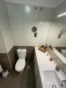 ein Badezimmer mit einem WC, einem Waschbecken und einem Spiegel in der Unterkunft Duplex con piscina cerca del mar in Puertito de Güímar