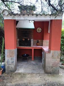 an outdoor kitchen with a stove in the middle at Casa rural en el campo con animales, piscina y barbacoa in Almodóvar del Río