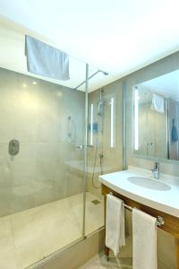 a bathroom with a glass shower and a sink at Hampton By Hilton Gaziantep in Gaziantep