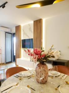 a table with a vase with flowers in it at Supernova Royal Residence in Novi Sad