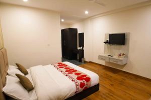 1 dormitorio con 1 cama y TV de pantalla plana en Hotel Merriment By VRB Hotels Dalhousie en Dalhousie