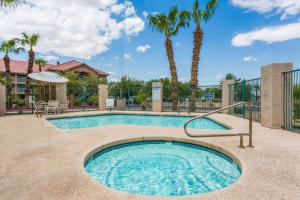 una piscina con palmeras en un complejo en Days Inn by Wyndham Phoenix West, en Phoenix