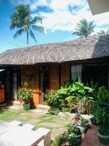 una casa con plantas delante de ella en Chào Hotel Mũi Né en Mui Ne
