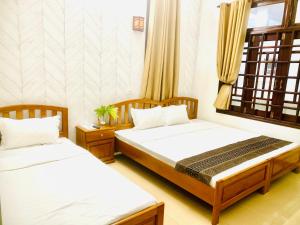 1 dormitorio con 2 camas y ventana en Chào Hotel Mũi Né en Mui Ne