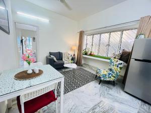 Olive Serviced Apartments Salt Lake Kolkata في كولْكاتا: غرفة معيشة مع ثلاجة وطاولة