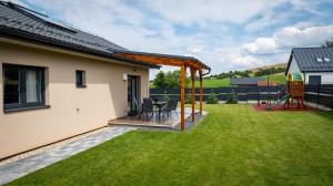 einen Hinterhof mit einer Holzterrasse und einem Spielplatz in der Unterkunft Porubáčik Liptov in Závažná Poruba