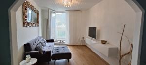 - un salon avec un canapé et une télévision dans l'établissement Casa Celeste by Quokka 360 - flat with a view of Lake Lugano, à Caslano