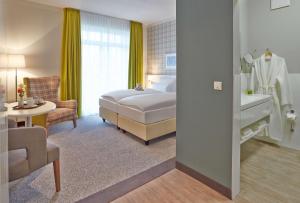 um quarto de hotel com uma cama e uma casa de banho em Dorint Resort Baltic Hills Usedom em Korswandt