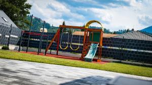 einen Spielplatz mit Rutsche in einem Park in der Unterkunft Porubáčik Liptov in Závažná Poruba