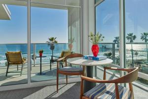The Seabird Ocean Resort & Spa, Part of Destination Hotel by Hyatt في أوشن سايد: غرفة مع طاولة وكراسي وإطلالة على المحيط