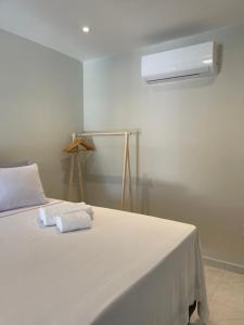 a white bed with two towels on top of it at Charlotte House in Canoa Quebrada +27 photos