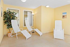 a waiting room with white chairs and a plant at Apartment-Residenz Ostseestrand Apartment-Residenz Ostseestrand 37 in Kühlungsborn