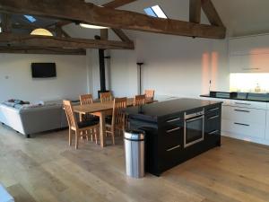a kitchen and dining room with a table and a couch at Red Brick Barn in Sutton under Brailes