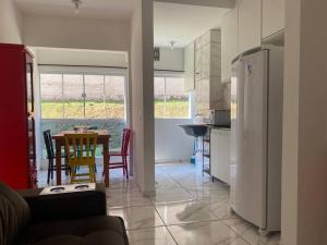 a kitchen and dining room with a table and a refrigerator at Apto Bela Vista 02 in Pôrto Ferreira