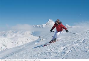 una persona está esquiando por una pista cubierta de nieve en Widderstein Apartments, en Schröcken