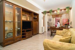 a living room with a tv and a couch and a dining room at Monti Rossi Home Holidays in Nicolosi