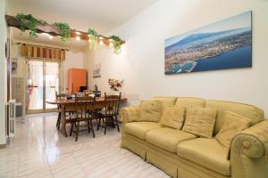 een woonkamer met een bank en een tafel bij Monti Rossi Home Holidays in Nicolosi