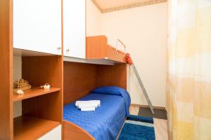 een kleine slaapkamer met een stapelbed met blauwe lakens bij Monti Rossi Home Holidays in Nicolosi