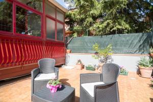 twee stoelen en een tafel op een patio met planten bij Monti Rossi Home Holidays in Nicolosi