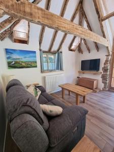 a living room with a couch and a table at Little Thatch in Corfe Castle