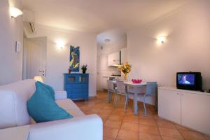 サンタ・テレーザ・ガッルーラにあるPerla Del Porto Apartmentsのリビングルーム(白いソファ、テーブル付)