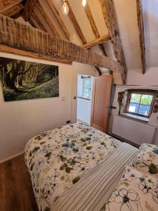 a bedroom with a bed with a comforter and a window at Little Thatch in Corfe Castle
