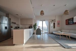 eine Küche und ein Wohnzimmer mit einem Sofa und einem Tisch in der Unterkunft House of Views a stunning apartment in Yas Island 609WB10 in Abu Dhabi