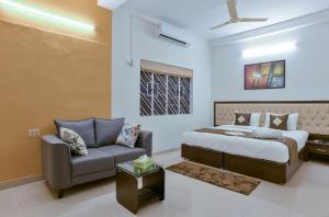 Olive Serviced Apartments Salt Lake Kolkata في كولْكاتا: غرفة نوم بسرير واريكة
