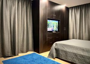 1 dormitorio con 1 cama y vestidor con TV en Tuikov’s Home Room, en Teteven