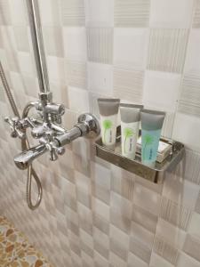 a shelf in a bathroom with four cups on it at Middleton Suites in Kiswera