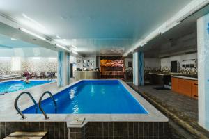 a large swimming pool in a room with a kitchen at Skif HOTEL & SPA in Petropavlovsk