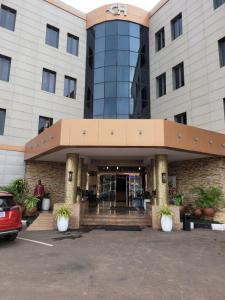 una entrada de hotel con un coche aparcado en un aparcamiento en Carlton Swiss Grand Hotel, en Enugu