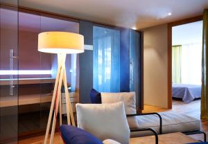 a living room with a couch and a lamp at Chalet Park Apartment mit Sauna Hamam in Diemtigen