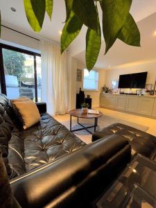 a living room with a leather couch and a table at 2bed house in Vauxhall in London