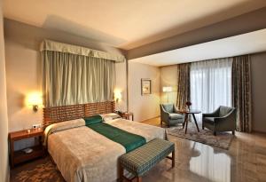 Una habitación de hotel con una cama y dos sillas. en Parador de Cordoba, en Córdoba 40 fotos más