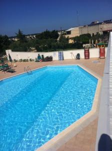 a large swimming pool with blue water at B&B Alicino in Cerfignano +22 photos