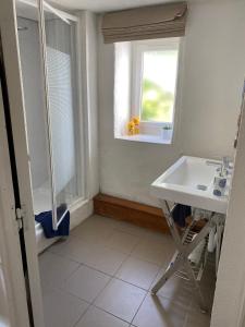 a bathroom with a sink and a window at Le petit gîte blanc, Langourla in Langourla