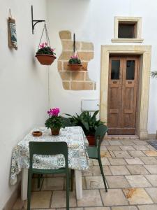 コペルティーノにあるNido d'amore in Salentoのテーブルと椅子2脚、テーブルとドア