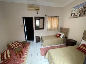 1 dormitorio con 2 camas, mesa y sillas en Riad Nour Travel-Les Riads Nour Resorts en Marrakech