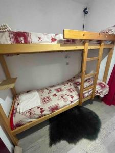 - 2 lits superposés dans une chambre avec un tapis au sol dans l'établissement Chaleureux Studio Montagnard avec balcon, à Prémanon