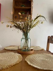 una mesa de madera con un jarrón con flores. en Chaleureux Studio Montagnard avec balcon en Prémanon