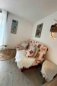 - un salon avec un canapé et une table dans l'établissement Chaleureux Studio Montagnard avec balcon, à Prémanon