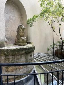 Una statua di leone seduta su un muro di Hôtel Prince de Conti a Parigi