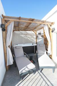 Una pérgola con sillas y un escritorio en un patio. en Oikia Atenea Automatic Rooms, en Agrigento