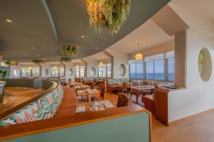 um restaurante com mesas, cadeiras e janelas em Pestana Vila Lido Madeira Ocean Hotel em Funchal