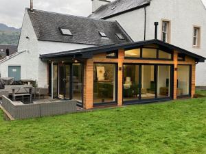 a house with large glass doors and a patio at Leirsinn Mhor in Killin