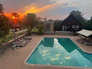 a swimming pool with chairs and a house at Rockey Mountain Tower in Bela-Bela