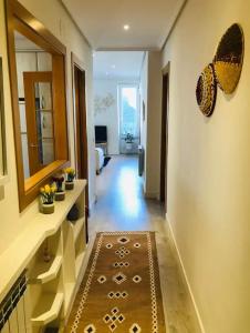 Una habitación con un pasillo con un espejo y una alfombra. en Lovely port apártement, en San Sebastián