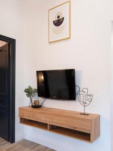 Un televisor de pantalla plana colgado en una pared en Le cocon Thérèse, en Metz