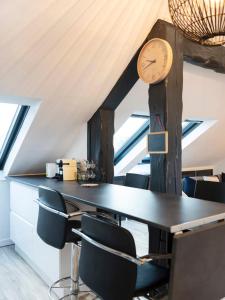 Habitación con mesa con sillas y reloj en Le cocon Thérèse, en Metz